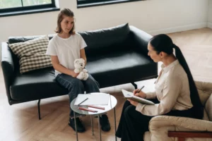 holding toy bear girl at a psychologist appointment