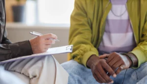 psychologist making notes and talking to patient
