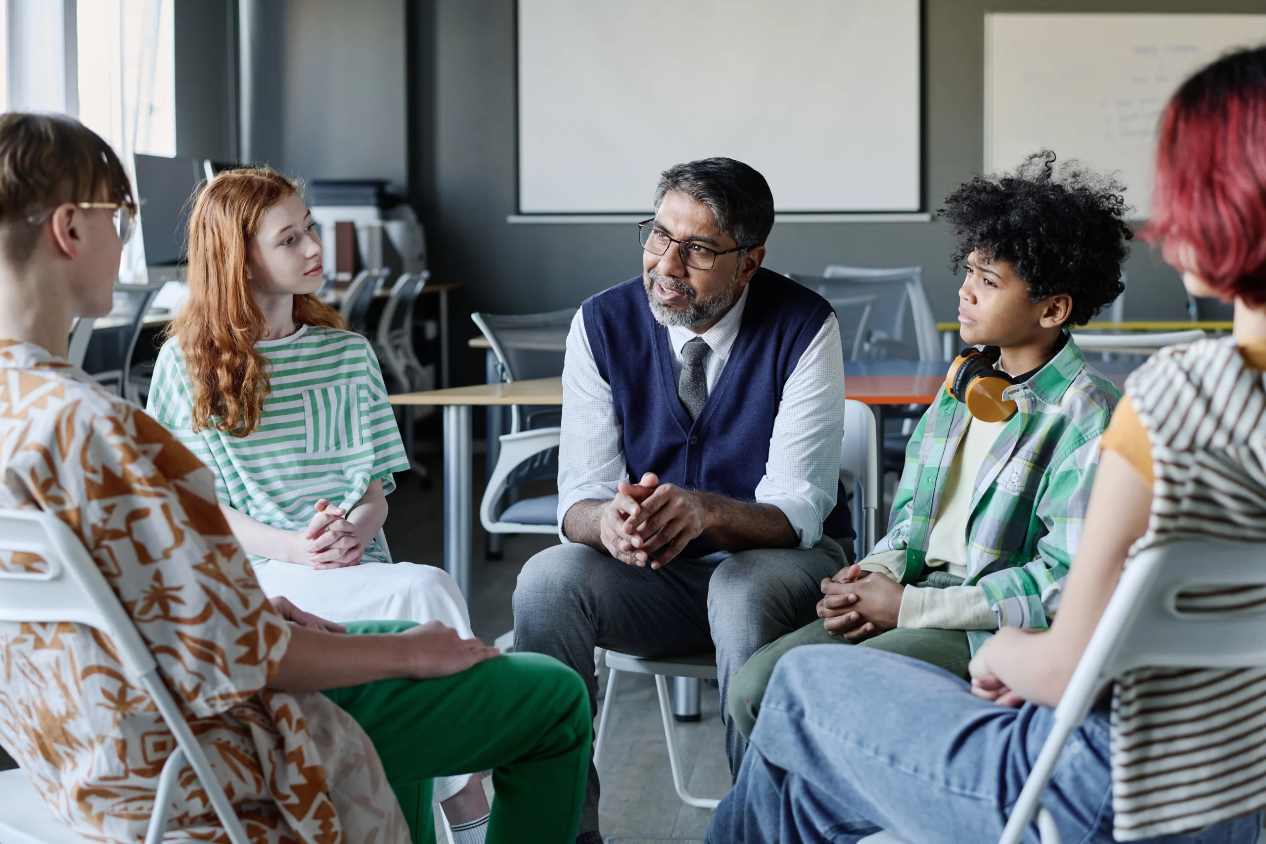 psychologist talking to group of teenagers